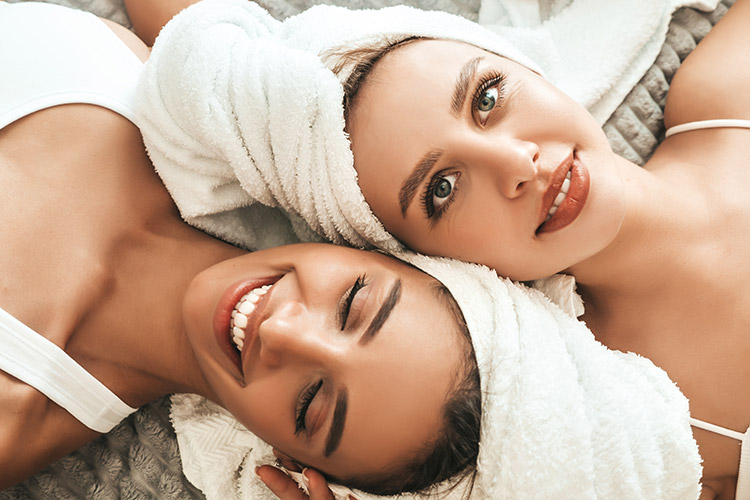 two-young-beautiful-smiling-women-white-bathrobes-towels-head
